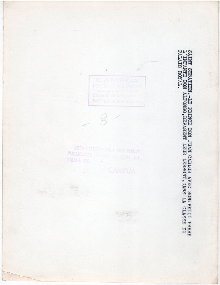 Reverso de la foto anterior, original de Campúa con la siguiente leyenda en francés: San Sebastián.- El Príncipe Don Juan Carlos con su hermano pequeño el Infante Alfonso repasan su lección en la clase del Palacio Real